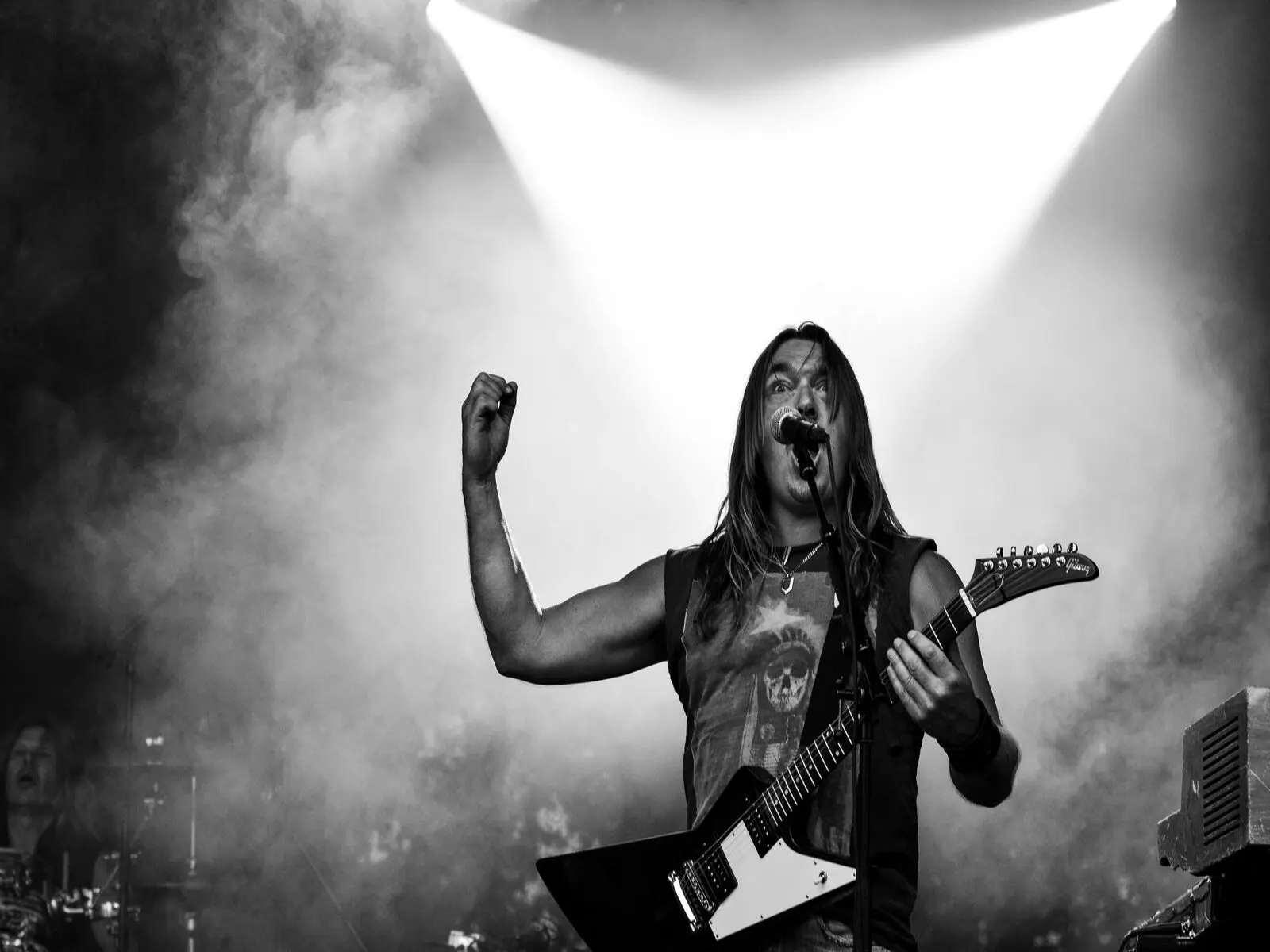 Growl: Technika Historia i Kultura Ekstremalnego Głosu 1 Black and white image of a rock musician playing guitar on stage during a dynamic concert performance.