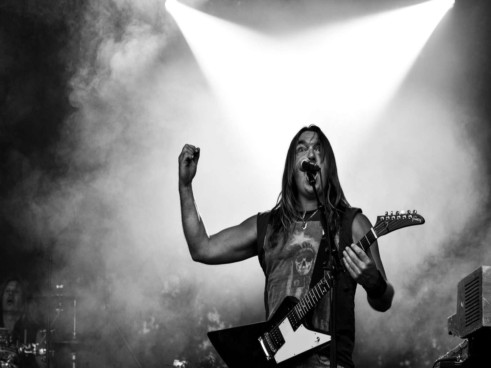 Growl: Technika Historia i Kultura Ekstremalnego Głosu 1 Black and white image of a rock musician playing guitar on stage during a dynamic concert performance.
