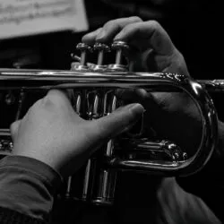 Photo by Gilles Gravier a person playing a trumpet in a black and white photo